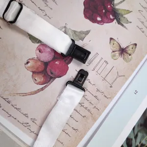 Cinturino per cravatta corto bianco con regolatori e clip in plastica nera, dettaglio.