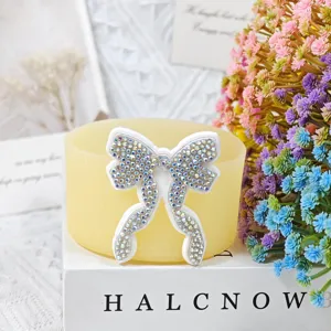 Detailed view of sparkly rhinestone bow silicone cup sleeve decoration for drinkware accessories.