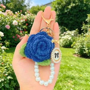 Handgemachter gehäkelter blauer Rosen-Schlüsselanhänger mit Perlenkette und Vintage-Schleife.