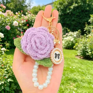 Nahaufnahme des handgemachten gehäkelten rosa Schlüsselanhängers mit Perlenband und Schleife.
