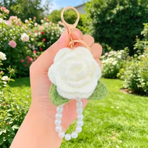 Handgemachte gehäkelte weiße Rosen-Schlüsselanhänger mit Perlenkette und goldenem Karabinerhaken.