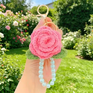 Handgemachte gehäkelte rosafarbene Rosen-Schlüsselanhänger mit Perlenarmband Detailaufnahme