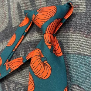 Vintage dark green necktie featuring a playful orange pumpkin print design for stylish daily wear.