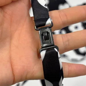Children tie buckle detail close up view, black and white printed fabric accessory.
