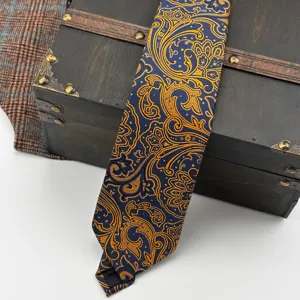 Close-up detail of luxury blue and gold paisley necktie with vintage court style pattern.