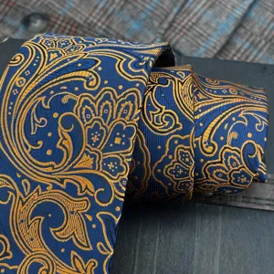 Close up of luxury blue and gold paisley jacquard tie, elegant vintage style fabric detail.