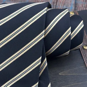 Corbata de rayas clásica para hombre, negra con rayas diagonales doradas, textura elegante.