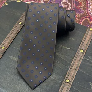 Detailed shot of mens brown jacquard tie with blue floral pattern, classic business suit accessory