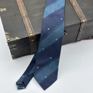 Vista dettagliata di una cravatta jacquard paisley blu sfumata da uomo, accessorio elegante.