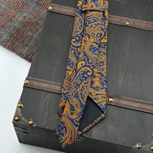 Detailed view of men's blue gold paisley patterned tie, vintage court style luxury necktie.