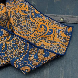 Close-up detail of luxury blue and gold paisley jacquard fabric showing exquisite craftsmanship.