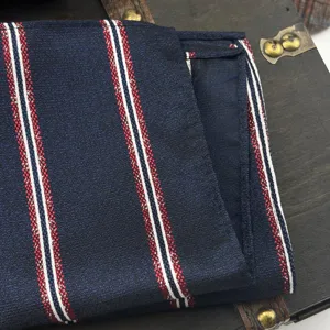 Detaillierte Nahaufnahme eines dunkelblauen Einstecktuchs mit roten und weißen Streifen.