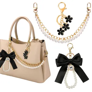 Parelketting tasbedel met zwarte strik, elegant accessoire voor handtas en chique sleutelhanger.