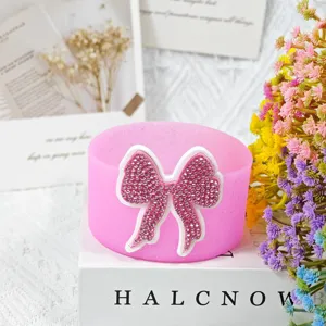 Pink silicone cup sleeve with sparkling rhinestone bow, detailed view for tumbler accessories
