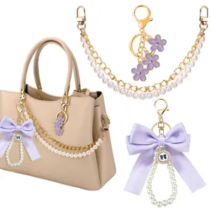 Gedetailleerd overzicht van parelketting en paarse strik tasbedel, elegante handtasaccessoire.