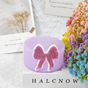 Close-up detail of purple silicone cup boot featuring a sparkly pink rhinestone bow decor.