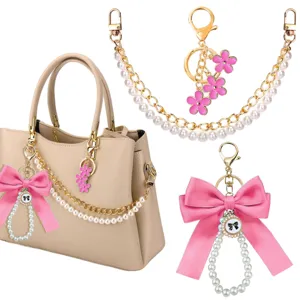 Gedetailleerd overzicht van parelketting tasriem met roze strik en schattige bloemen sleutelhanger.