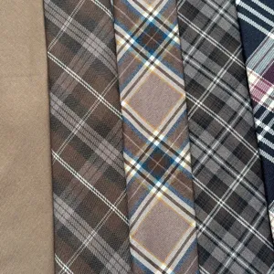 Close-up detail of retro brown plaid and solid neckties, perfect for classic college style.