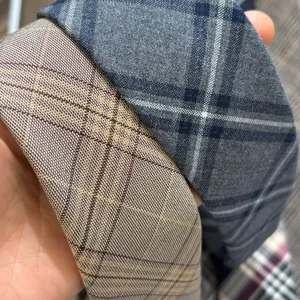 Close-up detail shot of vintage plaid ties showcasing fine fabric texture and dual colors.