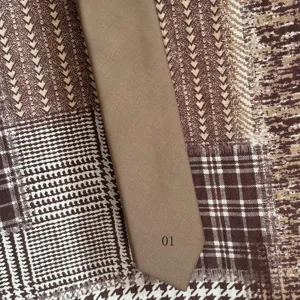 Retro brown tie detail view, classic American style necktie with fine twill texture and number.