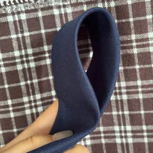 Vista detallada del tejido de corbata de poliéster mate azul marino, textura fina.