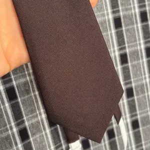 Corbata marrón lisa detalle, textura de tela estilo retro, accesorio vintage diario