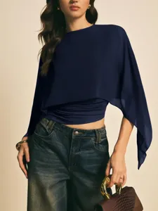 Vista detallada del top asimétrico de gasa azul oscuro para mujer con mangas de capa.