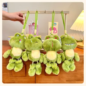 Close-up detail of cute dangling leg frog plush toy keychain hanging on display stand.