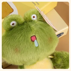 Cute green frog plush toy pendant close-up, soft furry texture and cute embroidered face.