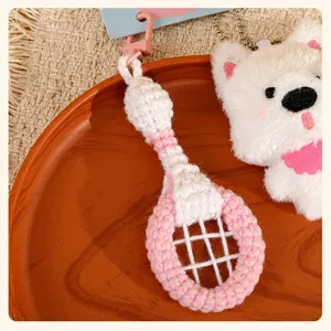Crochet badminton racket and white dog plush keychain detail view, cute bag pendant charm.