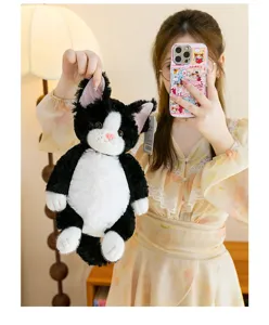 Close-up detail of the cute black and white cat plush toy, soft stuffed animal companion.