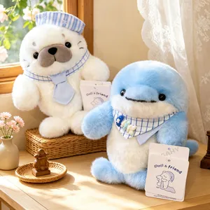 Detailed close-up of cute plush seal and dolphin toys wearing sailor hats and plaid bibs on desk.