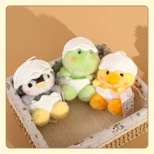 Vista detallada de adorables colgantes de peluche con cáscara de huevo, pingüino y dinosaurio.