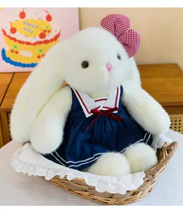 Cute lop-eared rabbit plush toy wearing a sweet blue sailor dress with a red bow.