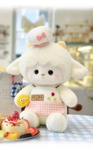 Mignon jouet en peluche mouton blanc avec toque de chef et tablier tenant fromage détail