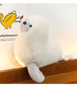 Close-up of cute white seal plush toy resting on wooden edge with warm background light.