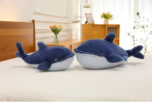 Soft blue whale plush toy detail scene on clean bed, cozy marine stuffed animal decor.