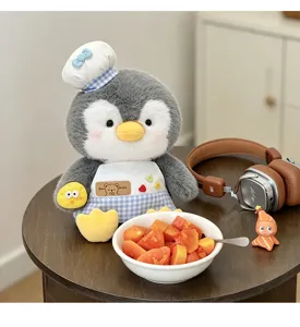 Vue détaillée de jolie peluche pingouin chef, poupée en peluche douce avec chapeau tablier.