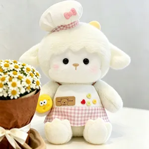Adorable peluche d'agneau blanc avec toque de chef et tablier à carreaux rose.