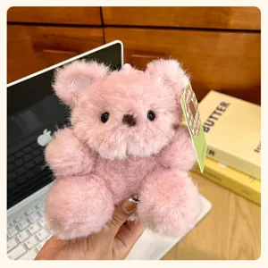 Cute pink fluffy teddy bear plush keychain detail view, soft toy pendant for bags and keys.