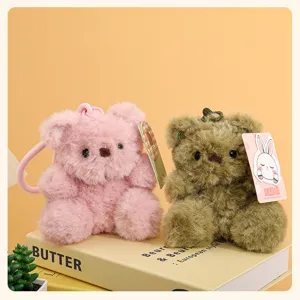Plush bear keychain detail shot, cute soft hanging pendant in pink and green colors for bags.
