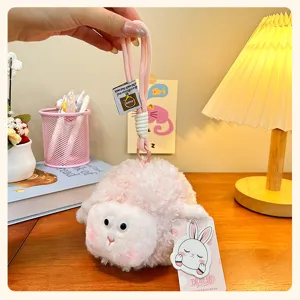 Detail view of the cute pink fluffy sheep plush keychain with soft fur and gold metal clasp hook.