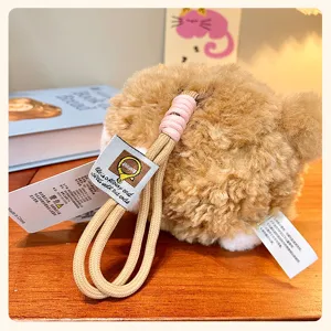Close-up detail of fluffy plush sheep keychain charm with lanyard and product tags.
