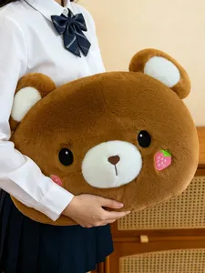 Close-up of soft brown bear plush pillow with cute strawberry embroidery for cozy home decor.