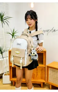Casual canvas backpack with cute plush doll keychain, stylish school bag for daily use.