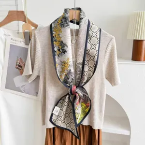 Detailed close-up of the double-sided silk blend ribbon scarf with elegant patterned prints.