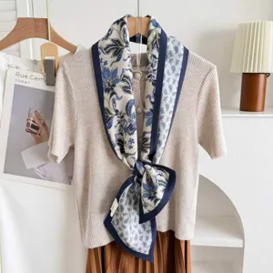 Detail shot of the luxurious double-sided silk blend ribbon scarf with elegant paisley print.