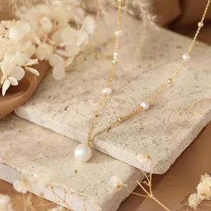 Französische Perlenkette Detail mit zarter Goldkette und elegantem Perlenanhänger.