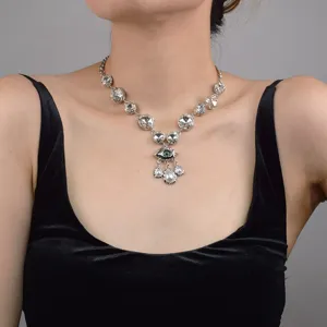 Detailed shot of a silver rhinestone evil eye necklace with pearl teardrop pendants.