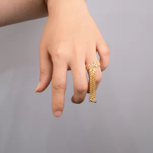 Detailed view of a luxury gold bow tassel ring with sparkling zircon for women index finger.